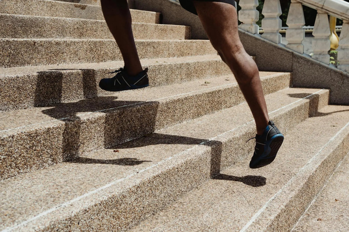 iemand met kramp in kuit op trap||kramp in kuit